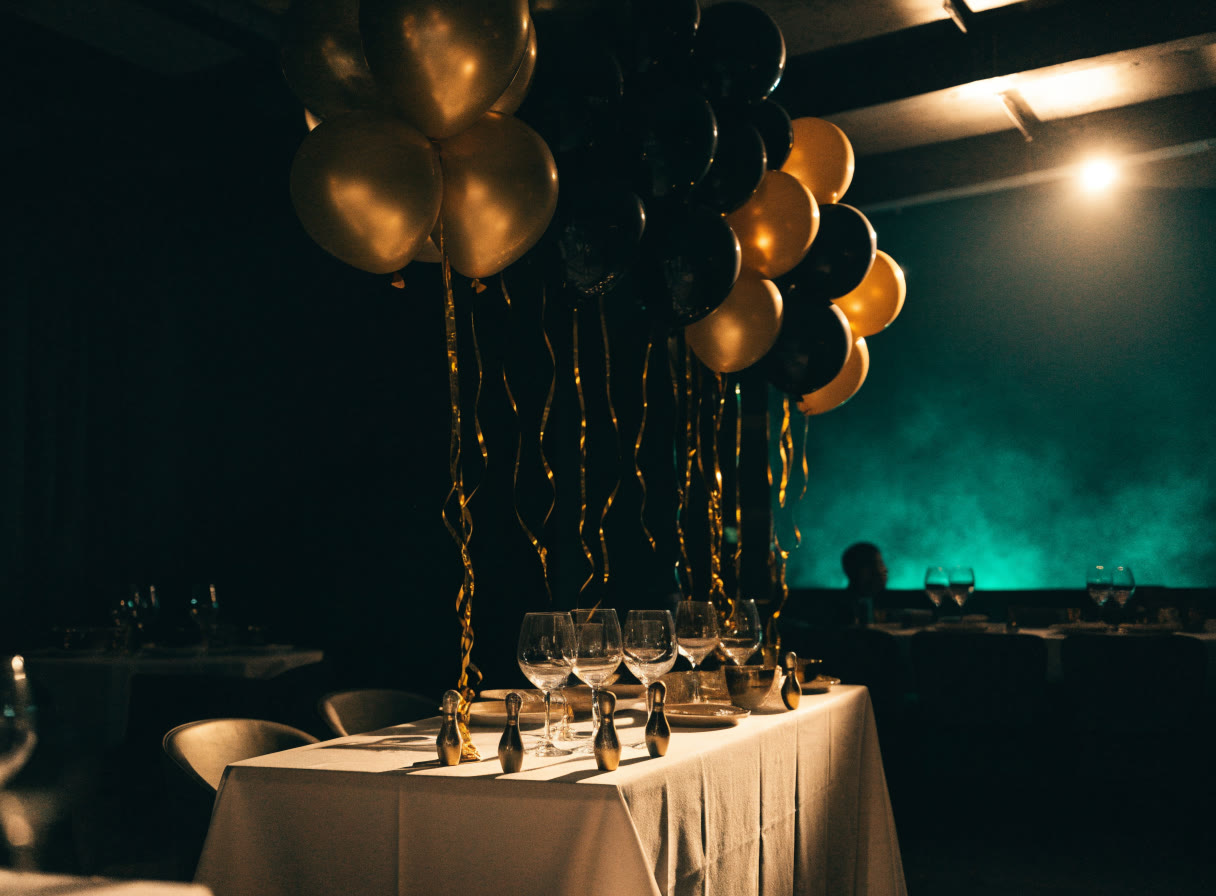 Mesa de fiesta con globos dorados y negros