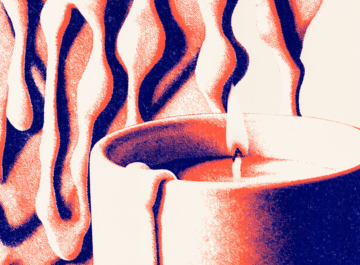Vela encendida en un vaso de cerámica con escurrimientos de cera