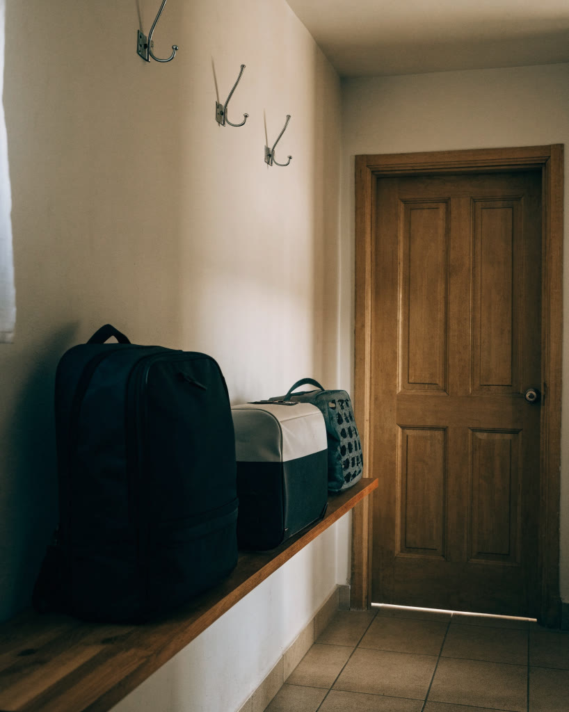 Vestíbulo de acceso a un hostal con repisa para equipaje
