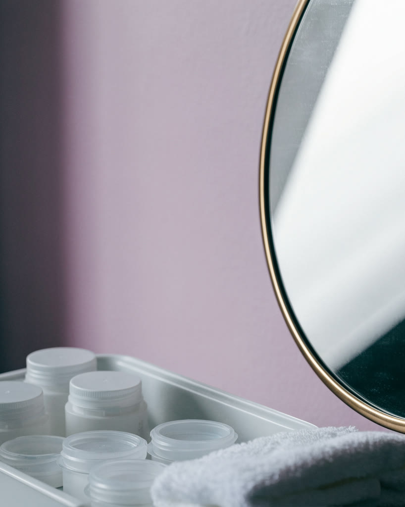 Probadores de skincare en una charola junto a un espejo