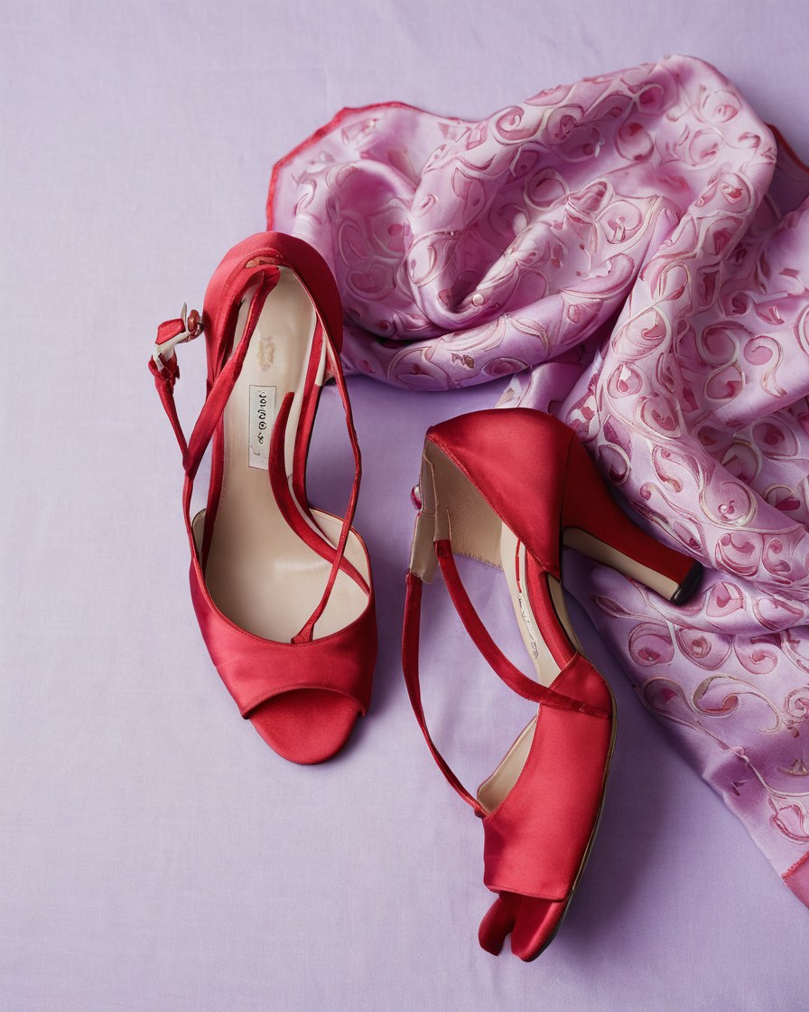 Zapatos vintage color cereza junto a un pañuelo de seda estampado sobre tela lila