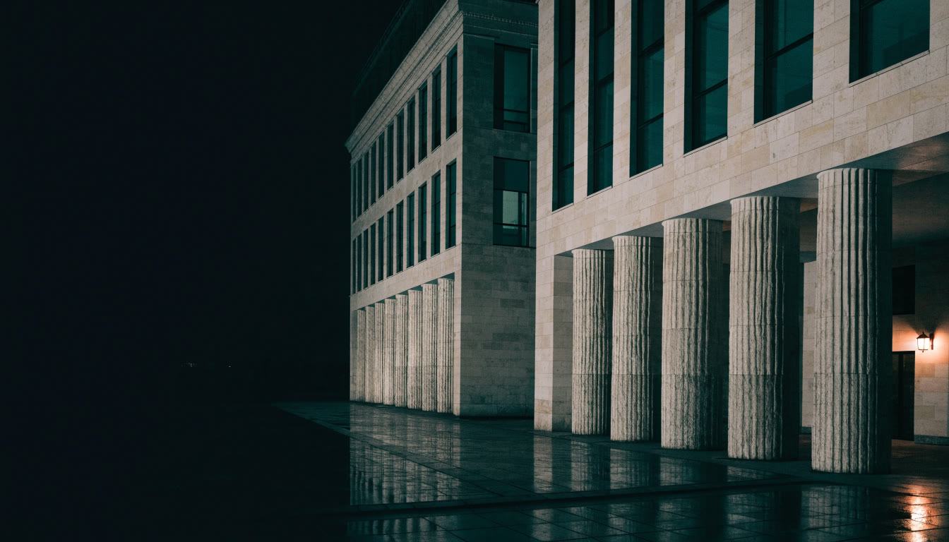 Fachada de piedra de un edificio institucional iluminada de noche