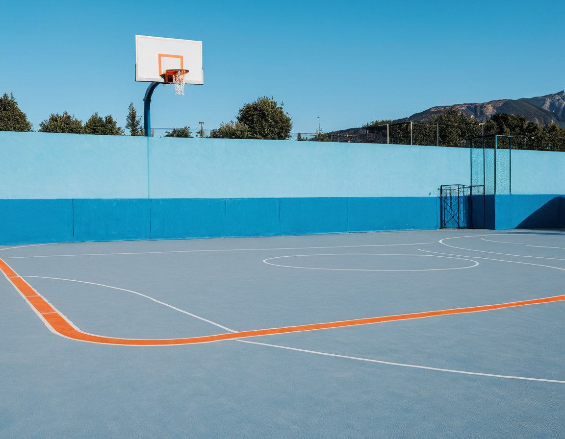 Cancha de básquetbol al atardecer con un balón sobre la línea